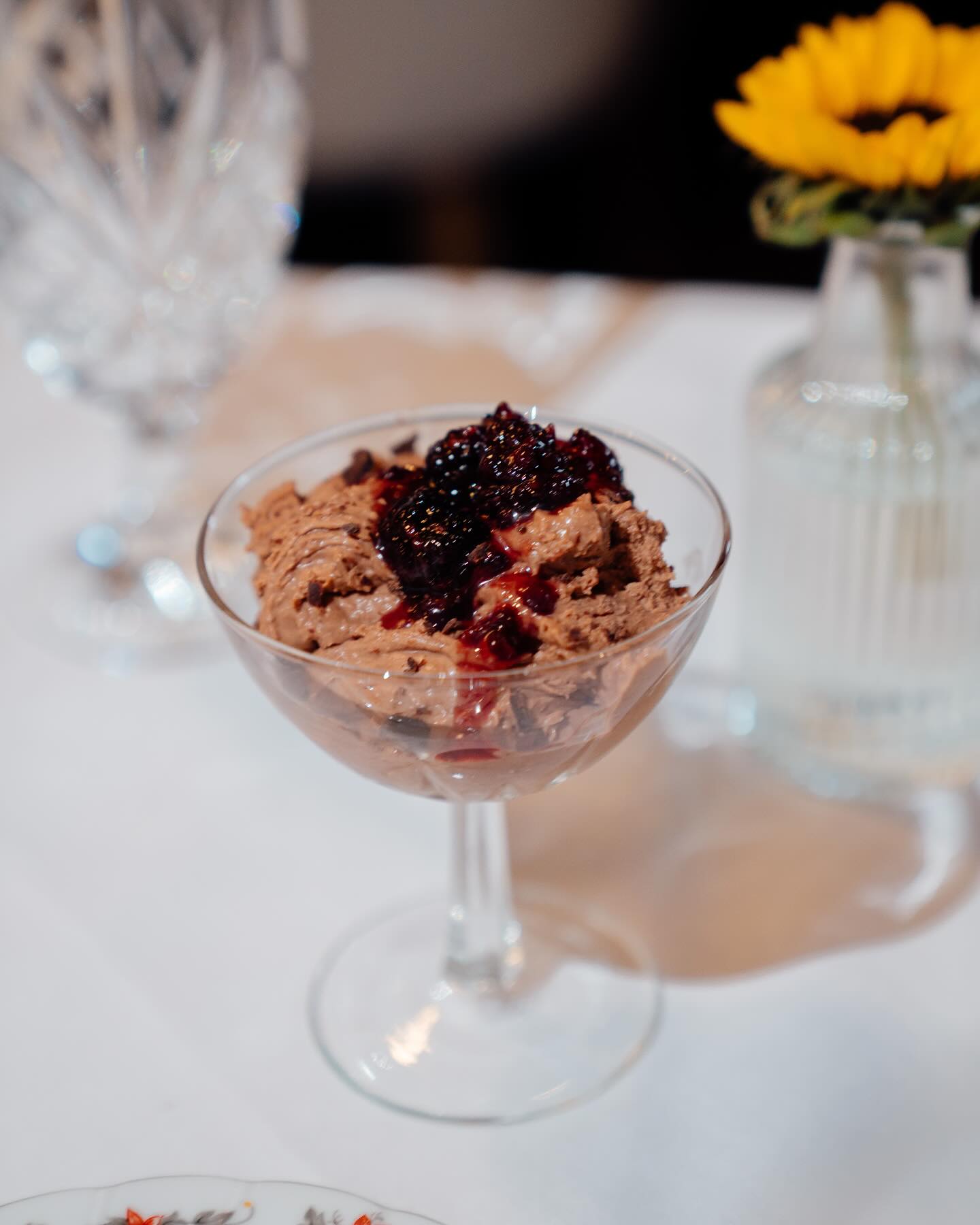 A chocolate dessert in a cut glass coupe with blackberries