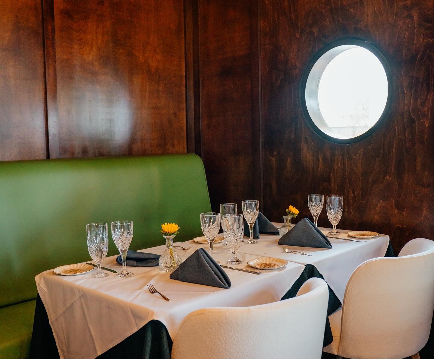 The panelled dining room with tables laid in navy and crystal